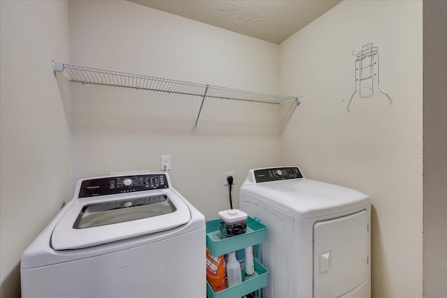 clothes washing area with a textured ceiling and washing machine and dryer