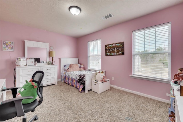 bedroom with a textured ceiling and light carpet