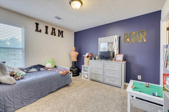 bedroom with a textured ceiling and carpet