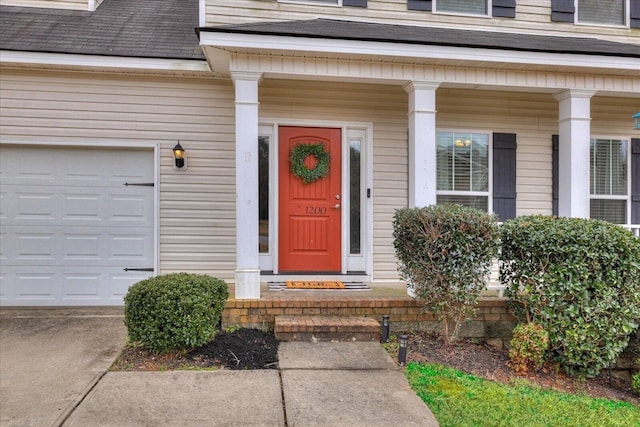 view of exterior entry with covered porch and a garage