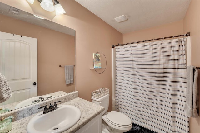 bathroom with toilet, a textured ceiling, walk in shower, and vanity