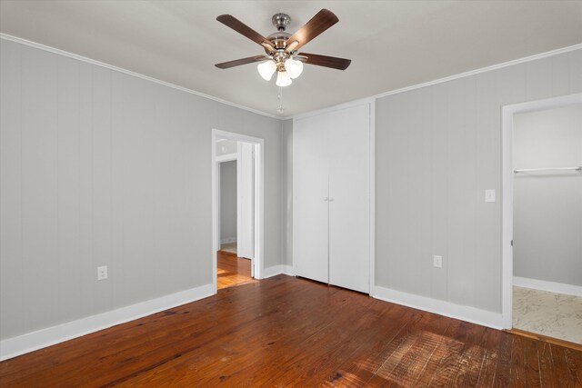 empty room with ceiling fan, wood-type flooring, and ornamental molding