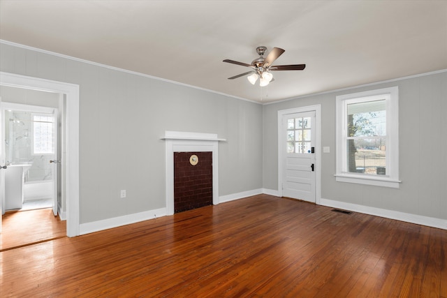 unfurnished living room featuring ceiling fan, wood-type flooring, and ornamental molding