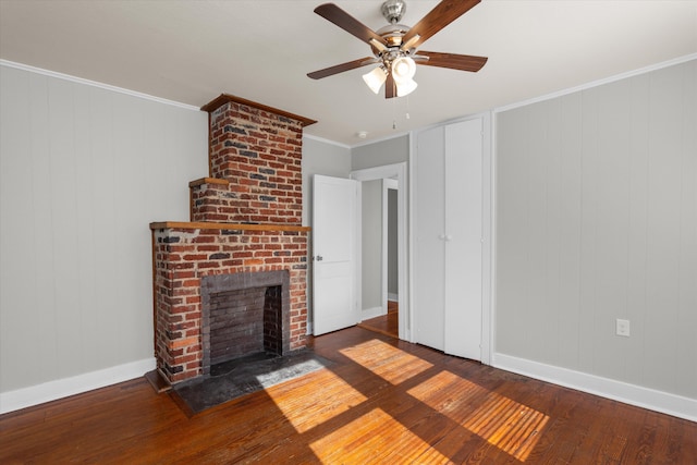 unfurnished living room featuring ceiling fan, a fireplace, dark hardwood / wood-style floors, and ornamental molding