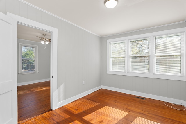 empty room featuring hardwood / wood-style floors, ceiling fan, and crown molding