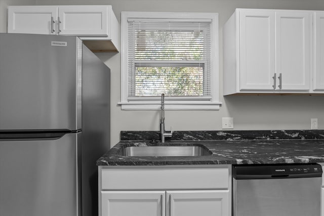 kitchen with dark stone counters, sink, white cabinets, and stainless steel appliances