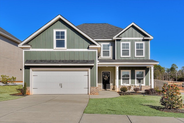 craftsman house with a garage, a front yard, and a porch