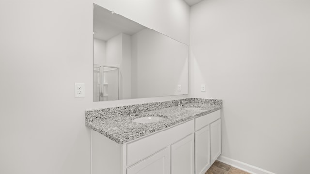 full bathroom with a sink, baseboards, and double vanity