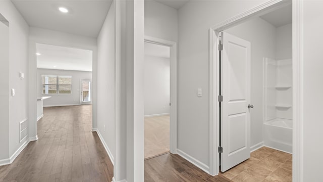 hall featuring wood-type flooring, baseboards, recessed lighting, and visible vents