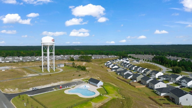 drone / aerial view featuring a wooded view and a residential view