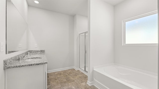 full bathroom with baseboards, vanity, a stall shower, and a garden tub