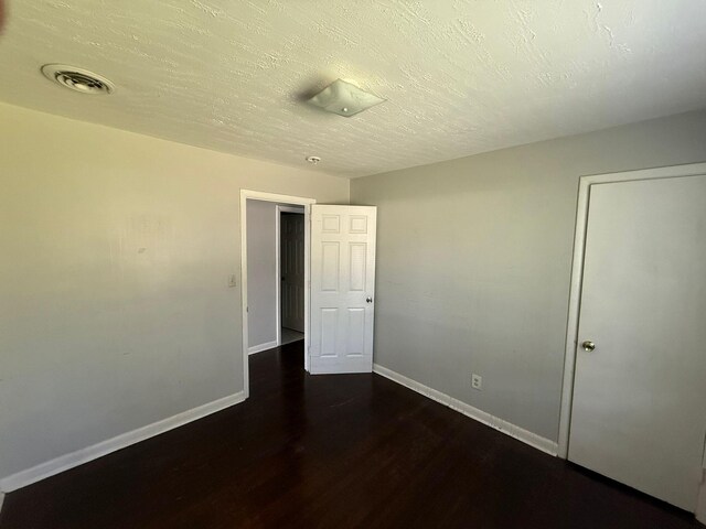 3314 Forest Estates Dr, Augusta, GA 30909 - unfurnished bedroom with baseboards, dark wood-type flooring, and a textured ceiling