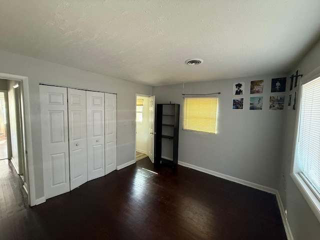 3314 Forest Estates Dr, Augusta, GA 30909 - unfurnished bedroom featuring baseboards, dark wood-style floors, multiple windows, and a textured ceiling