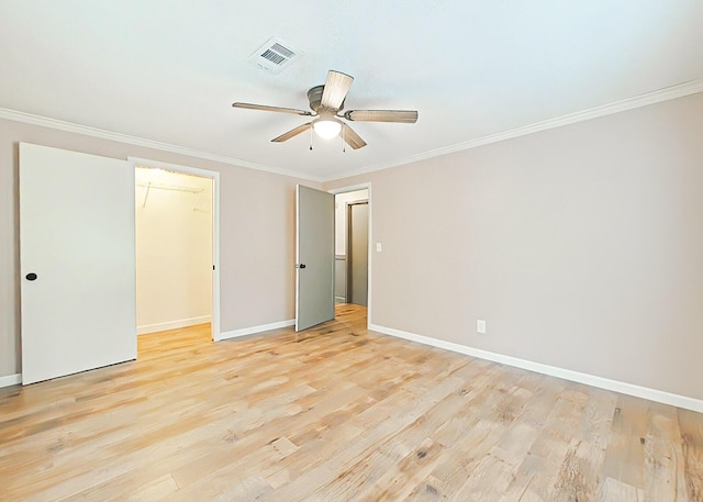 5850 Jaime Dr, Grovetown, GA 30813 - unfurnished bedroom with crown molding, light wood-type flooring, a walk in closet, and ceiling fan