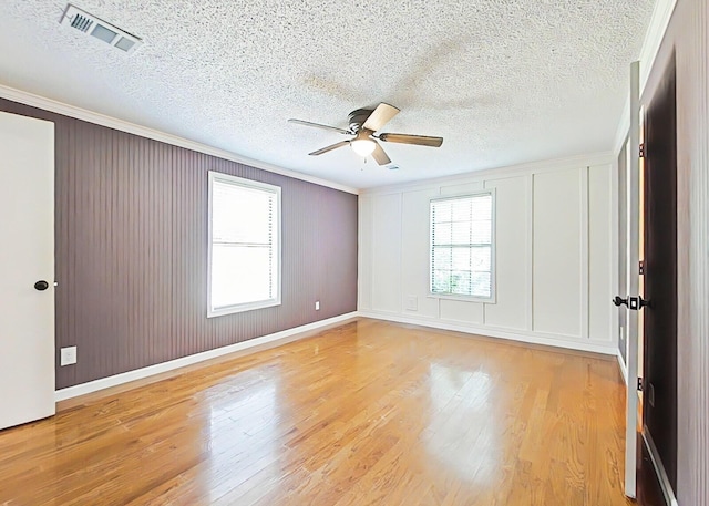 5850 Jaime Dr, Grovetown, GA 30813 - spare room featuring a ceiling fan, ornamental molding, light wood-style flooring, a textured ceiling, and a decorative wall