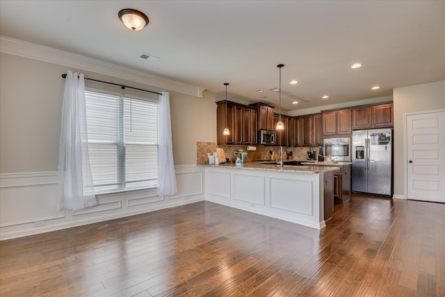 336 Shell Brooke Way, Lexington, SC 29073 - kitchen with stainless steel appliances, a peninsula, a wainscoted wall, light stone counters, and dark wood finished floors