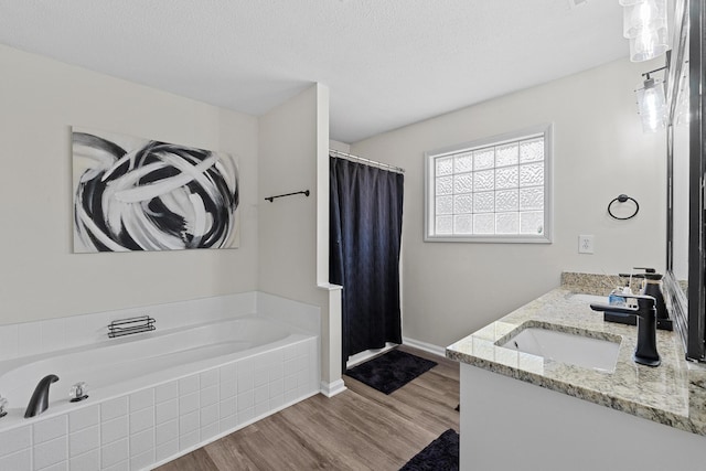 3235 Warwick Pl, Hephzibah, GA 30815 - bathroom featuring a shower stall, a garden tub, wood finished floors, double vanity, and a textured ceiling