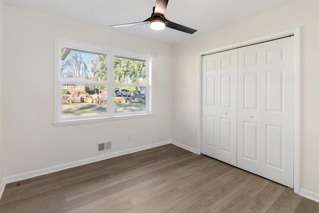 unfurnished bedroom featuring ceiling fan, light hardwood / wood-style floors, and a closet