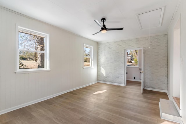 unfurnished bedroom with ceiling fan, brick wall, and light hardwood / wood-style floors