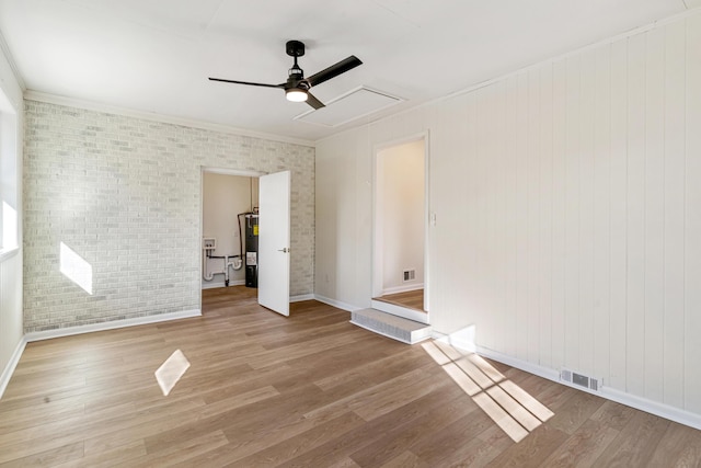 unfurnished bedroom featuring electric water heater, crown molding, ceiling fan, wood-type flooring, and brick wall