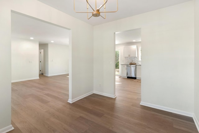 corridor featuring light hardwood / wood-style floors and a notable chandelier