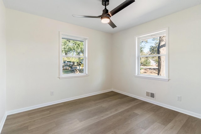 empty room with ceiling fan and light hardwood / wood-style flooring