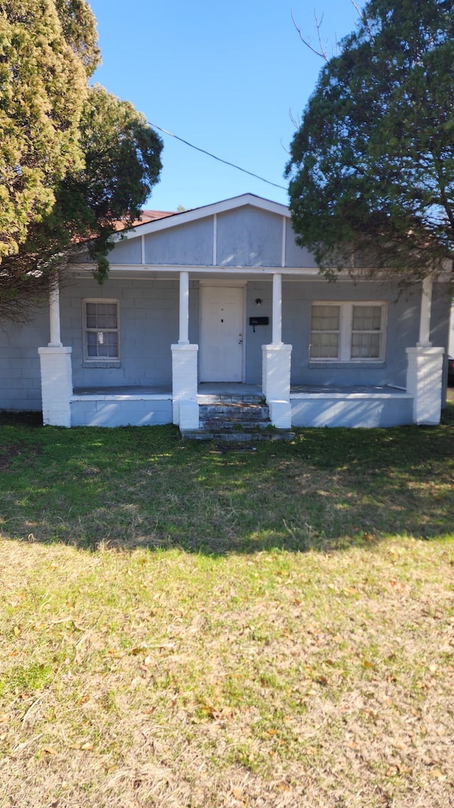 view of front of property with covered porch and a front yard