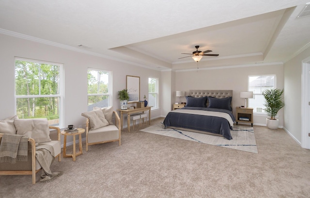 carpeted bedroom with visible vents, multiple windows, a tray ceiling, and ornamental molding