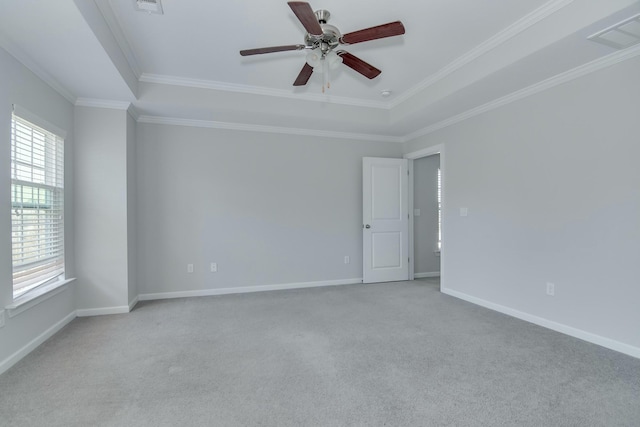 empty room featuring visible vents, baseboards, carpet, and crown molding