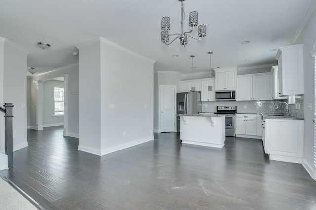 kitchen with a sink, crown molding, a kitchen island, and stainless steel appliances