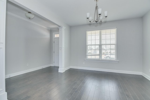 unfurnished room with decorative columns, baseboards, an inviting chandelier, and dark wood-style flooring