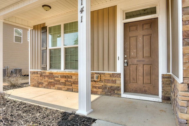 doorway to property with stone siding and a porch