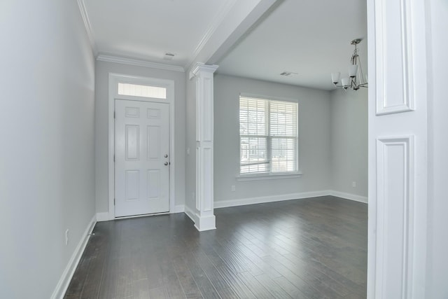 entryway featuring dark wood-style floors, visible vents, an inviting chandelier, decorative columns, and crown molding