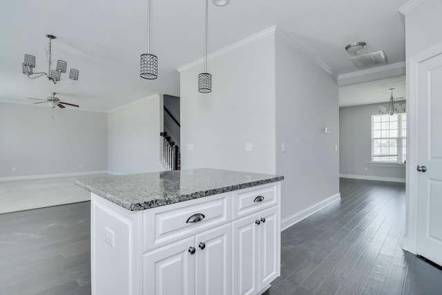 kitchen featuring dark stone countertops, baseboards, ornamental molding, dark wood-type flooring, and white cabinets