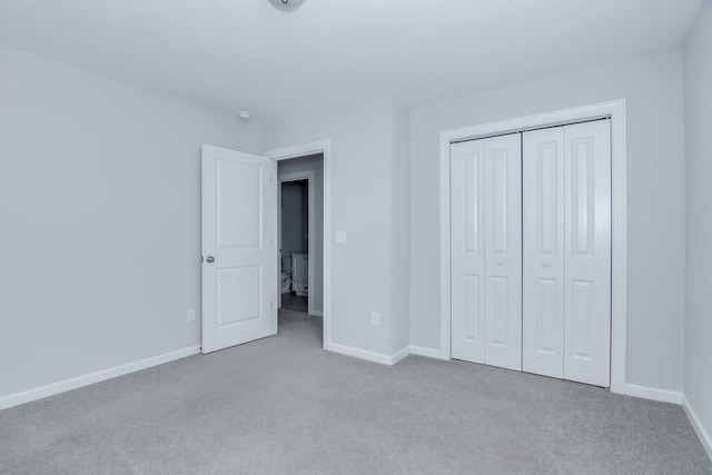 unfurnished bedroom with a closet, baseboards, and carpet