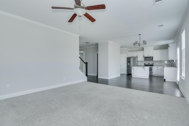 unfurnished living room with baseboards, a sink, stairs, ornamental molding, and ceiling fan with notable chandelier