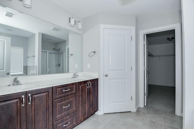 full bath with tile patterned floors, visible vents, a shower stall, and a sink