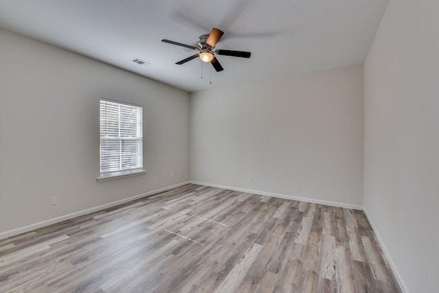 unfurnished room featuring visible vents, ceiling fan, baseboards, and wood finished floors