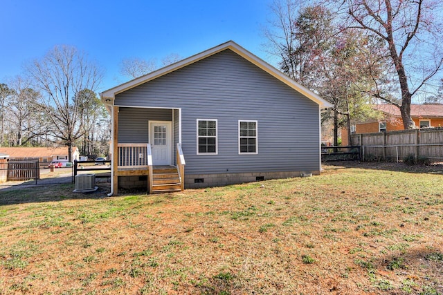 rear view of house with a yard, crawl space, and fence