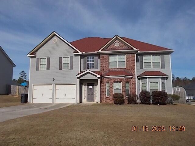 view of front of property with a front yard and a garage