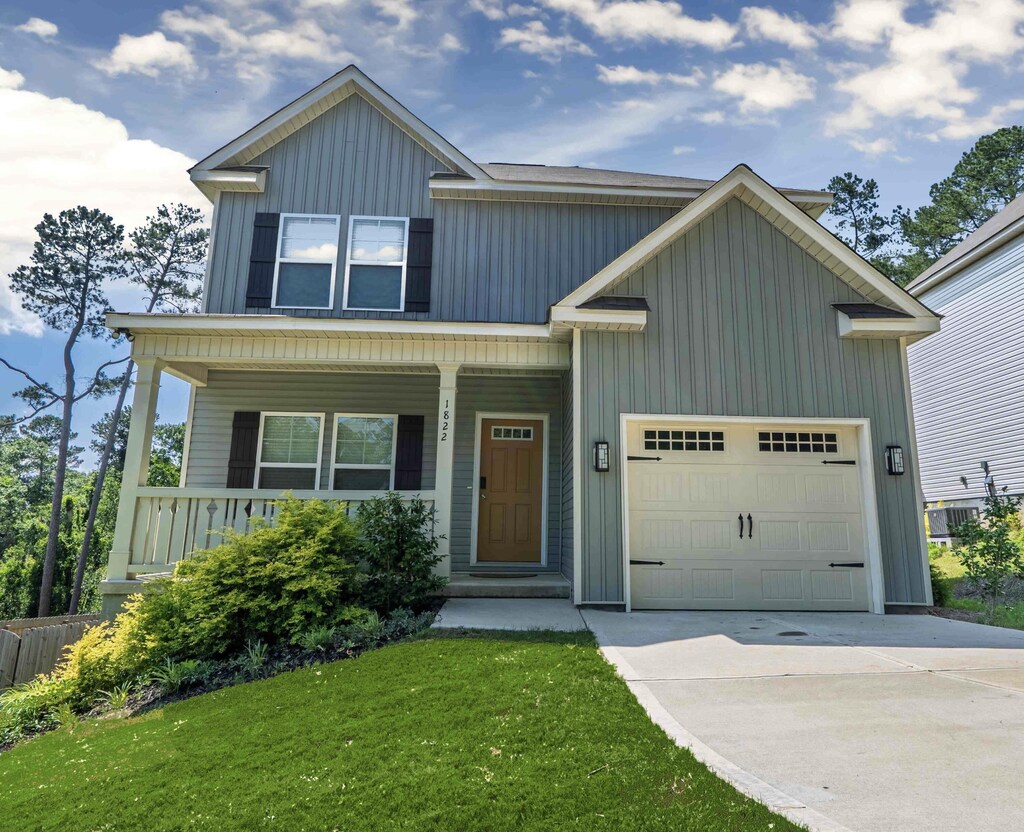 1822 Lowe St, North Augusta, SC 29841 - view of front of home with a garage, a front yard, board and batten siding, covered porch, and concrete driveway