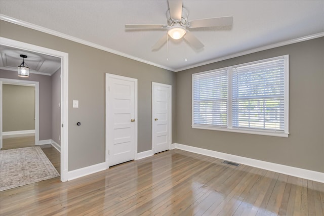 empty room with hardwood / wood-style floors, baseboards, and visible vents