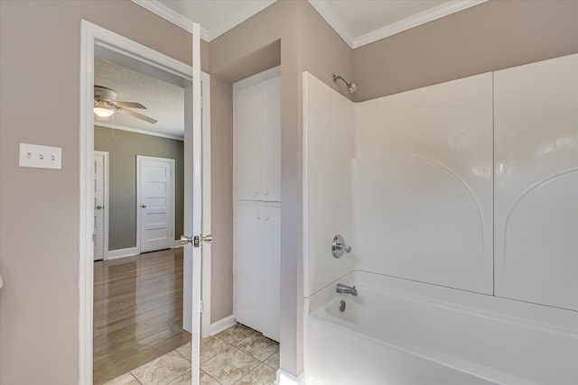 bathroom featuring a ceiling fan, baseboards, ornamental molding, and shower / bathing tub combination