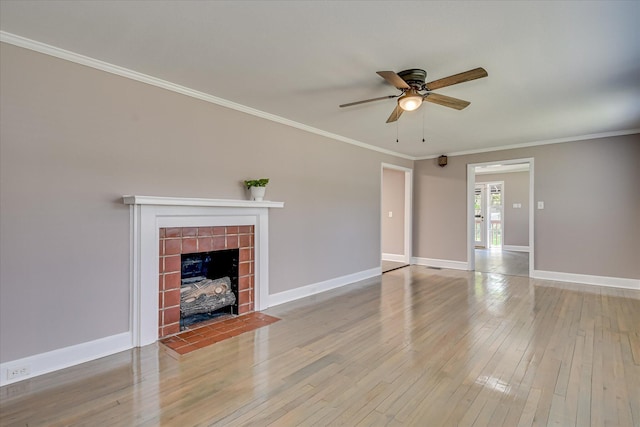 unfurnished living room with baseboards, ceiling fan, crown molding, hardwood / wood-style floors, and a fireplace