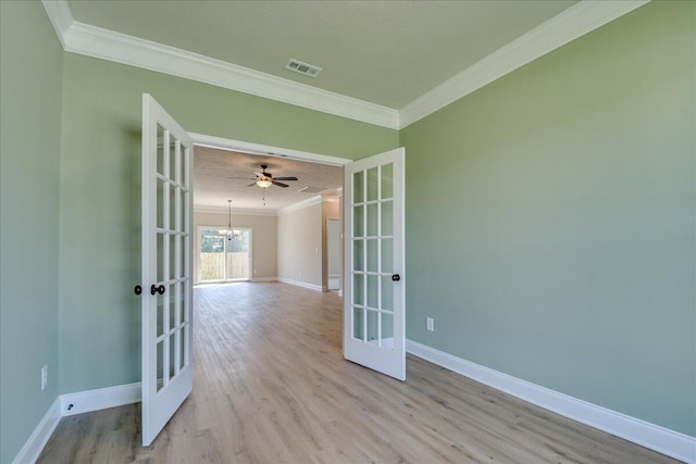 unfurnished room featuring crown molding, light hardwood / wood-style floors, and french doors