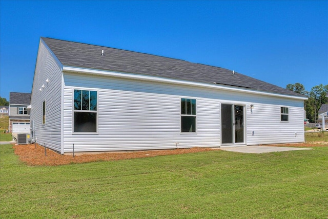 rear view of house featuring a yard and central air condition unit