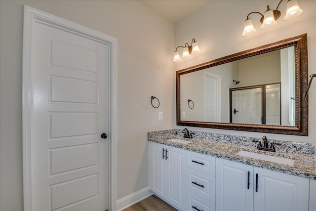 bathroom with vanity, hardwood / wood-style floors, and a shower with door