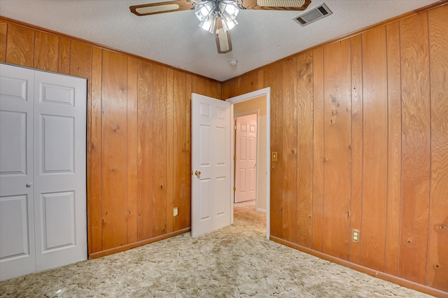 3115 Arcadia Dr, Augusta, GA 30906 - unfurnished bedroom featuring carpet, a textured ceiling, wood walls, and a ceiling fan