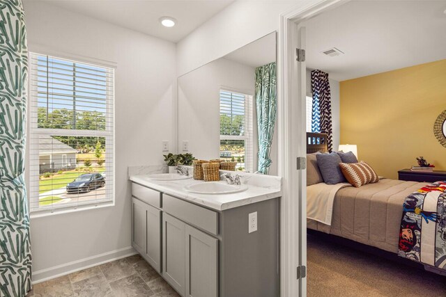 bedroom featuring ensuite bath, light colored carpet, and a closet