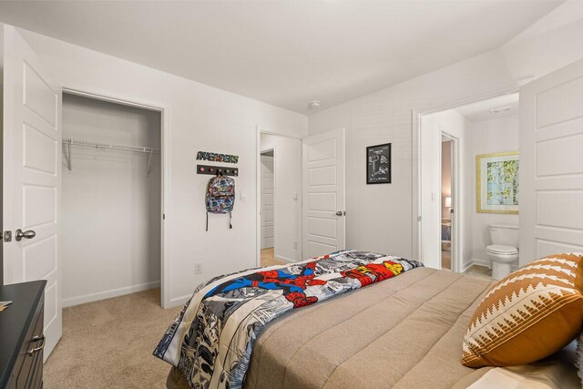 carpeted bedroom featuring ensuite bathroom and a closet